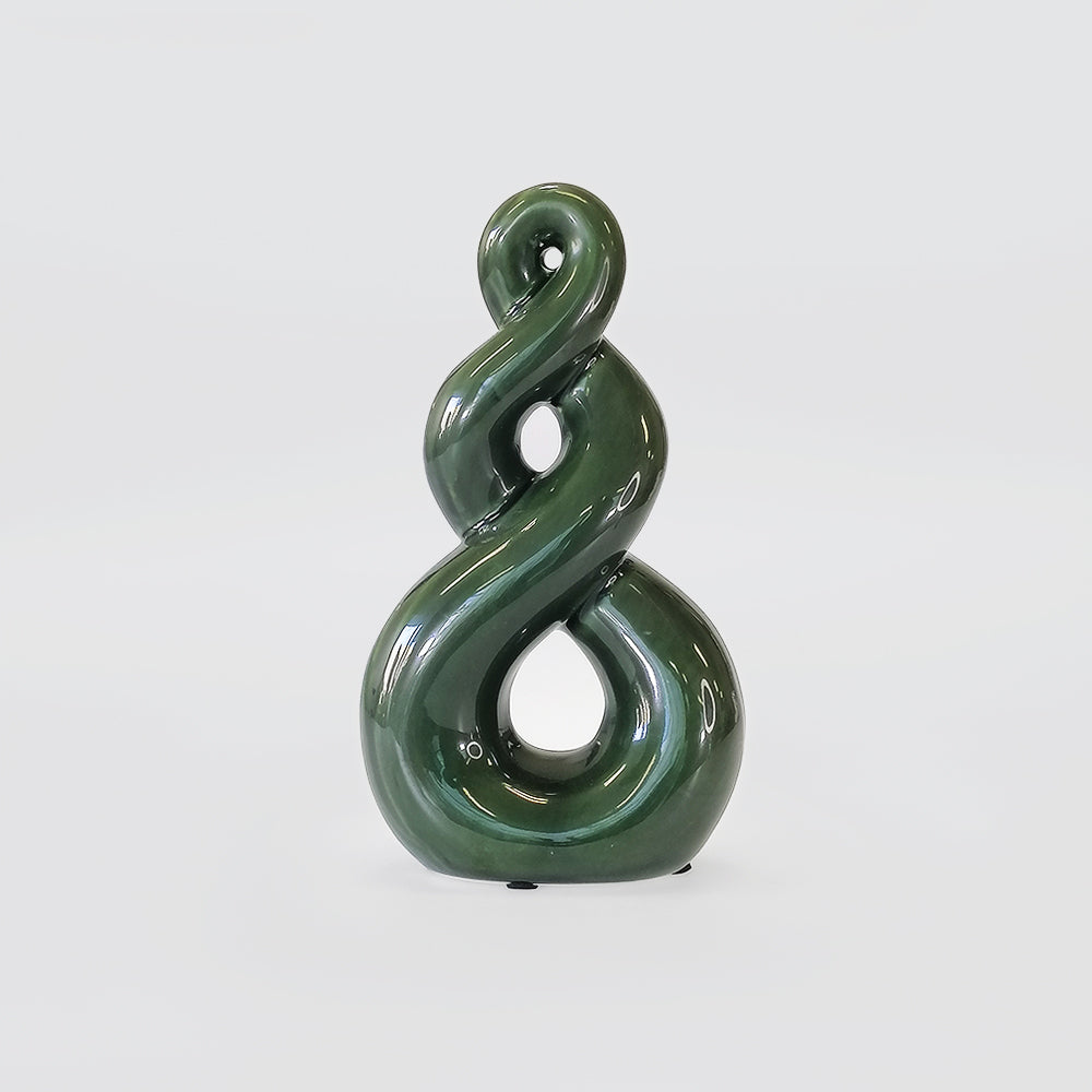 Green ceramic sculpture with a spiral design on a white background