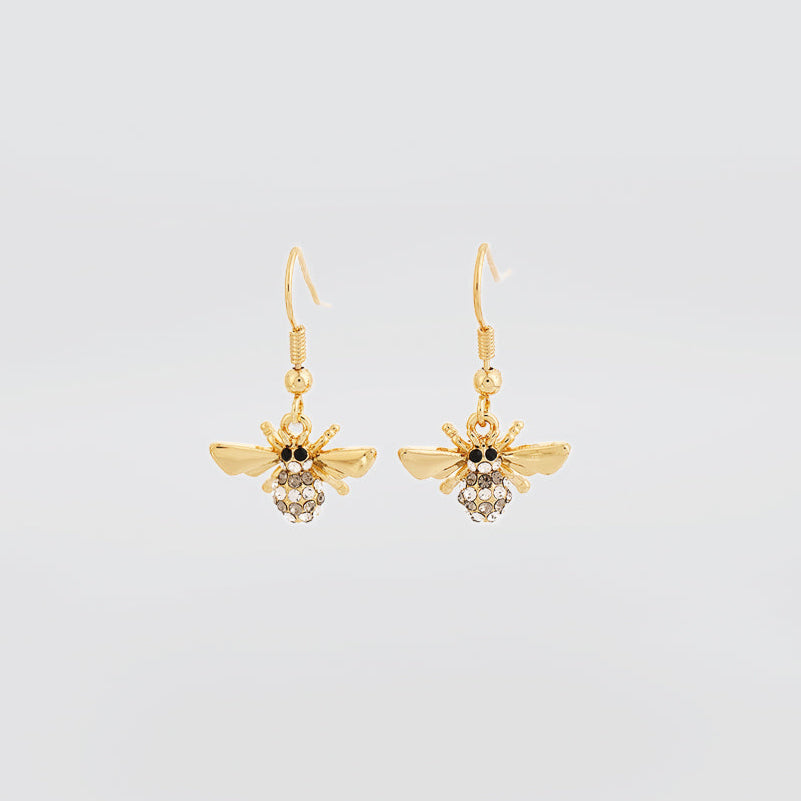 Gold bee-shaped earrings with gemstones on a light gray background